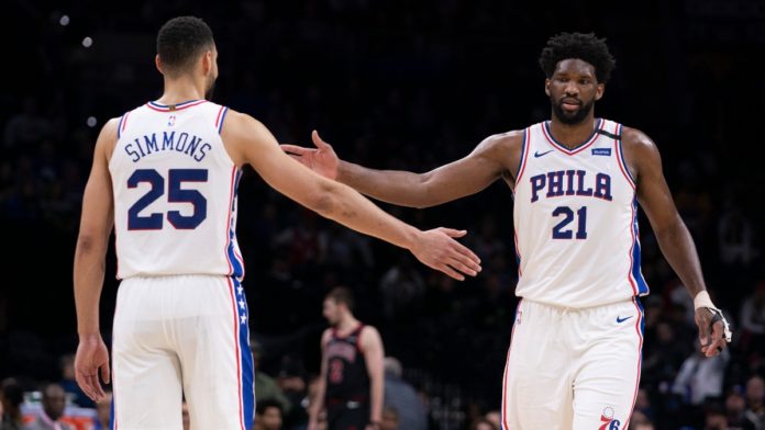 Joel Embiid and Ben Simmons high fiving during a game.