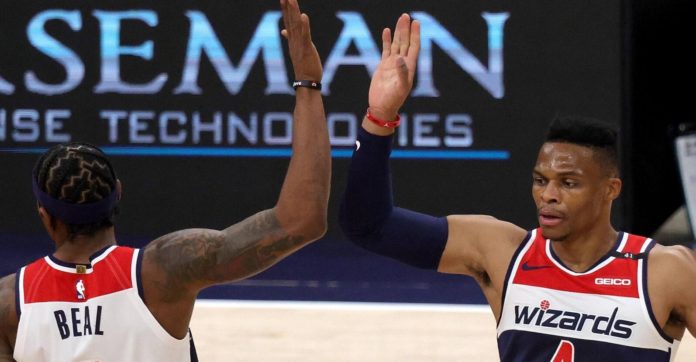 Wizards stars Bradley Beal and Russel Westbrook high fiving during a game.