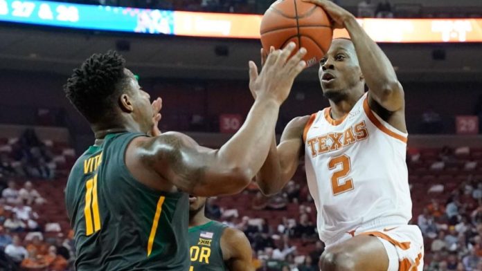 A Baylor basketball defender stifling a Texas basketball player.