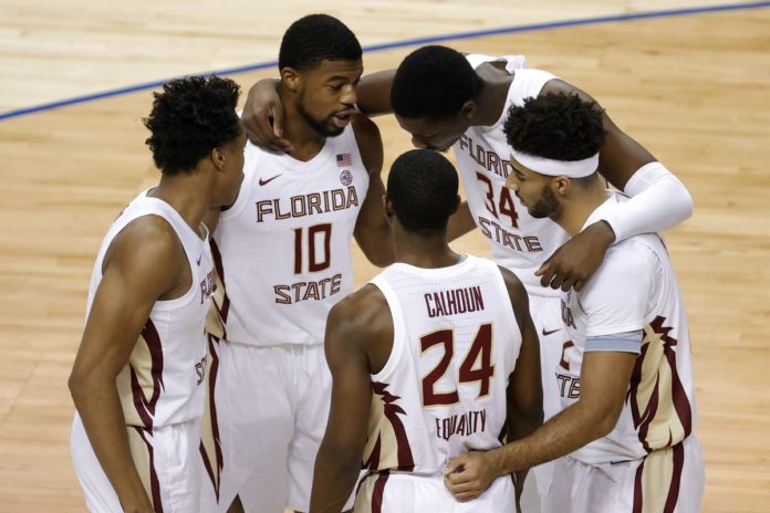 Florida State basketball players huddled up on the court.