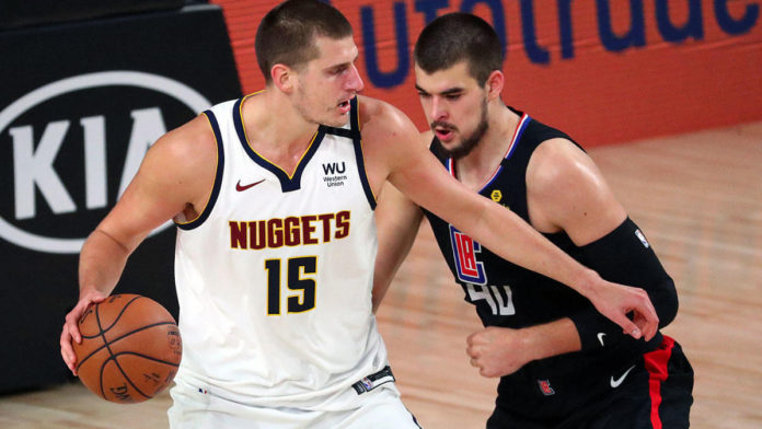 Nuggets' center Nikola Jokic posting up against an LA Clippers player.