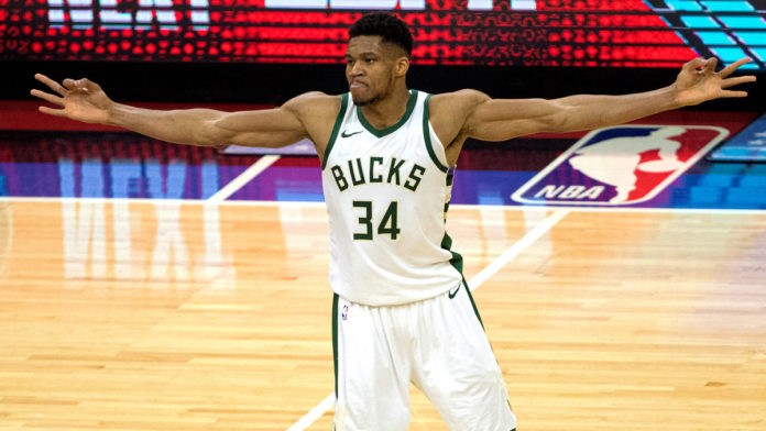 Bucks' star Giannis flexing on the court.