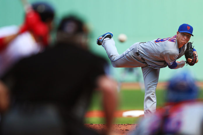 Jacob deGrom throwing a pitch against a Red Sox hitter.