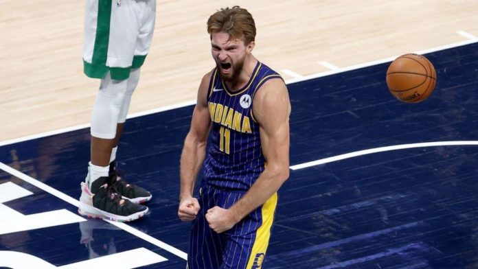 Domantas Sabonis, flexing after a slam dunk in a game.