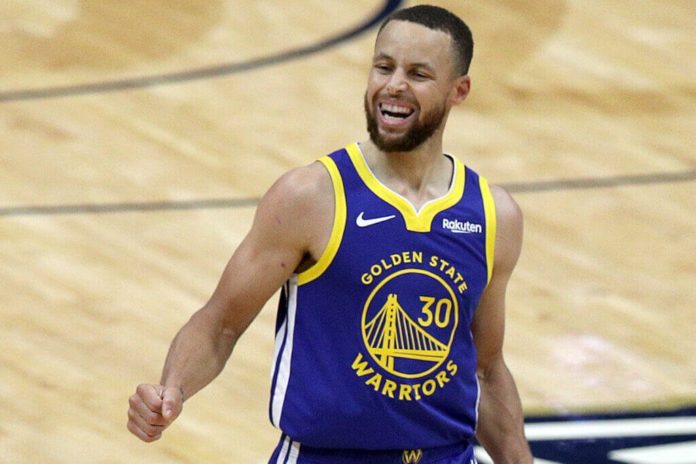 Steph Curry smiling on the court after a big 3 point shot.