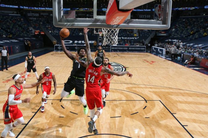 A shot of the Pelicans and Timberwolves' players battling at the rim.