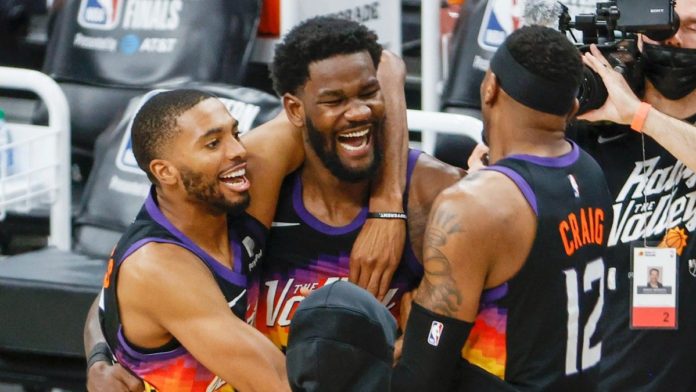 DeAndre Ayton and other Suns' players hugging after another big playoff win.