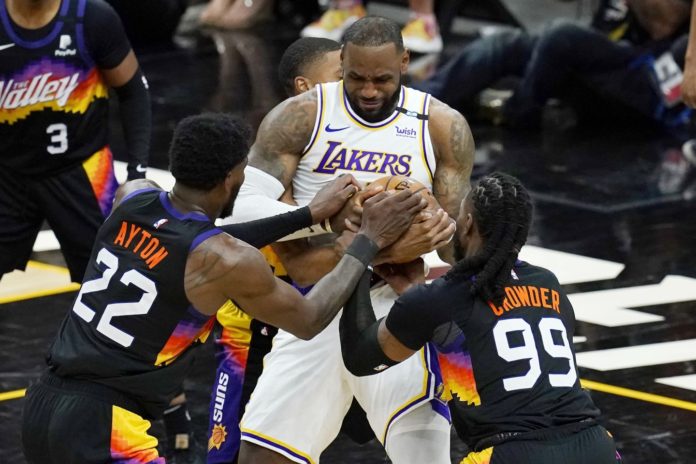 Suns and Lakers players vying for the ball in a playoff game.
