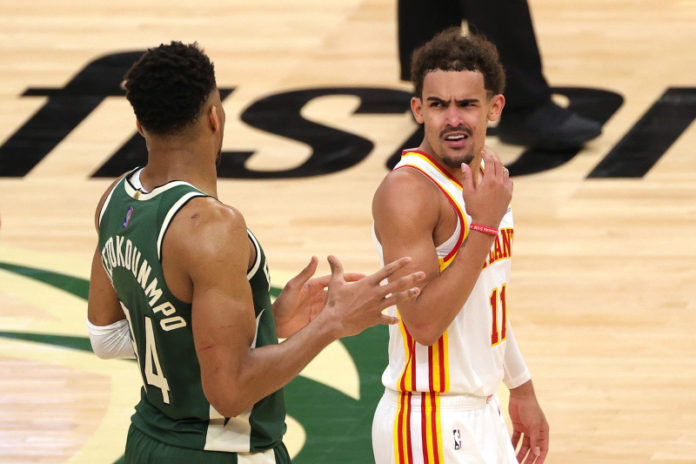 Trae Young talking to Giannis after a foul.