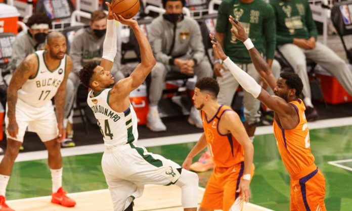 Jul 14, 2021; Milwaukee, Wisconsin, USA; Milwaukee Bucks forward Giannis Antetokounmpo (34) shoots against Phoenix Suns center Deandre Ayton (22) during the third quarter during game four of the 2021 NBA Finals at Fiserv Forum. Mandatory Credit: Jeff Hanisch-USA TODAY Sports