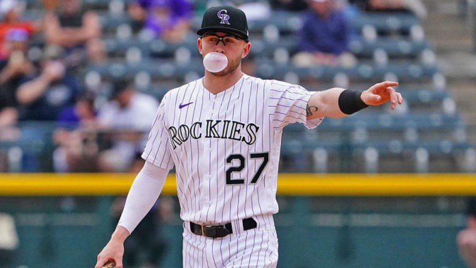 A Rockies player blowing a bubble gum bubble during a game.